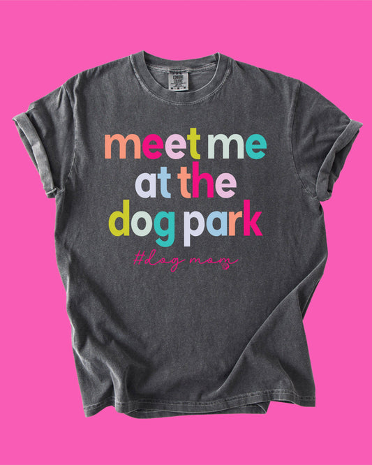 Gray t-shirt with colorful text 'meet me at the dog park' on a pink background