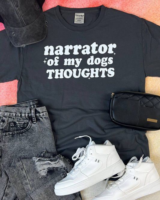 Black t-shirt with 'narrator of my dogs THOUGHTS' text, white sneakers, black jeans, and black waist bag on a colorful background.